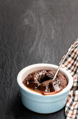 Hot chocolate lava cake in clay pot on black stone background