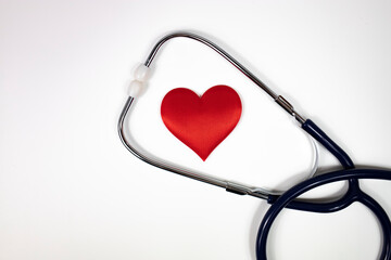 A stethoscope and a red heart on a white background. Top view.