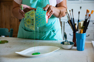 Woman artist mixing shades of paint, preparing for art project