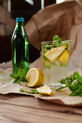 glass with fresh mojito with lemons and mint on craft paper on the table