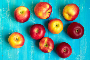 Bright red and yellow apples on a blue background.