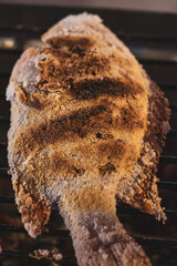 Food concept. Fish covered with salt making on grill in Thailand fresh food market. Center of image is in camera focus with shallow depth of field
