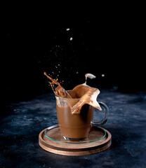 Coffee splash from a cup on dark background