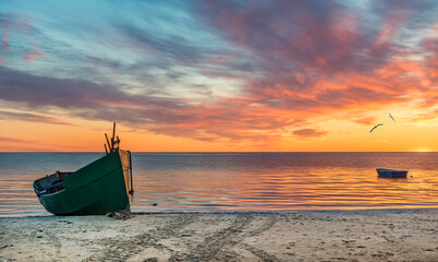 Anchored on sandy beach fishing boats near a small village of fishermen; here, at the Baltic Sea, ...