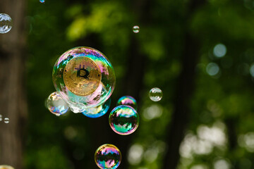  Gold Coins Bitcoin in a soap bubble. The concept of instability of the crypto currency, electronic...