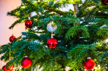A closeup shot of a Christmas ball on a Christmas tree decorated with led lights