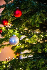 A closeup shot of a Christmas ball on a Christmas tree decorated with led lights