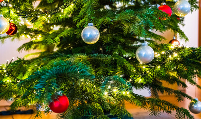 A closeup shot of a Christmas ball on a Christmas tree decorated with led lights