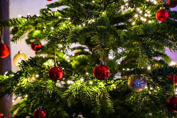 A closeup shot of a Christmas ball on a Christmas tree decorated with led lights