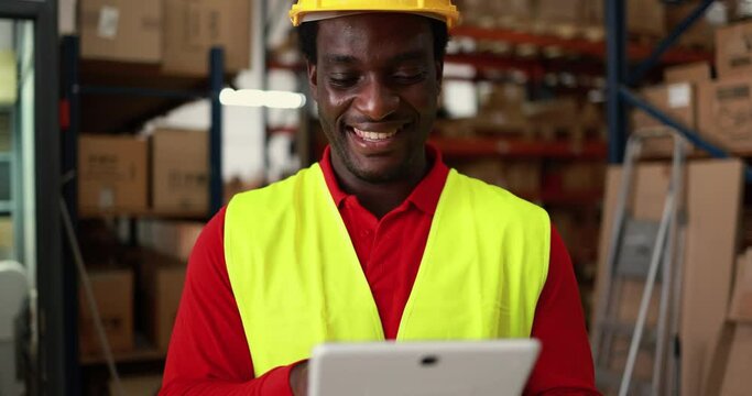 Happy african worker man using tablet inside warehouse - Industrial and technology concept