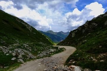 curvy road between mountains in the summer