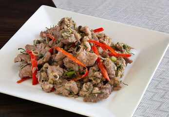 Fried pork with shrimp paste in white dish Thai food on wooden table