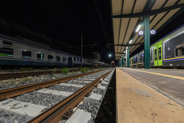 Fototapeta na wymiar Railway station with train waiting on the tracks at night