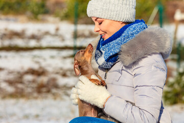 Woman playing with dog during winter