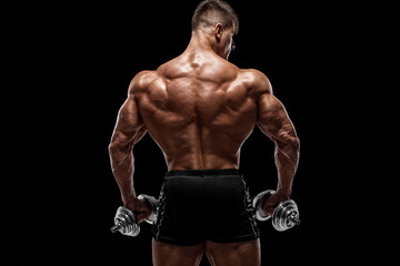 Muscular man showing back muscles, isolated on black background. Strong male rear view