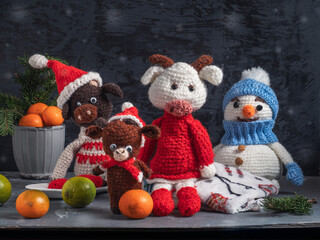 Handmade crocheted toys. A snowman in a blue hat and bulls in red caps