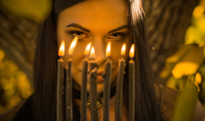 Portrait of mysterious lady with a candle, magic and rituals concept. Attracting beauty happiness, love etc