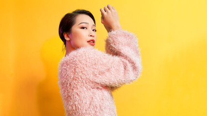 Portrait of pretty lady in pink warm over yellow background