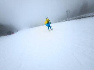 young woman skier sliding down by snowed slope