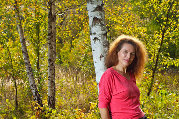 Portrait of a woman in nature. Happy woman in summer on a background of grass, flowers, greenery, forest.