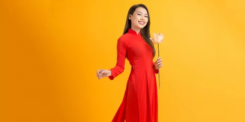 Poster Portraits of cute lady with Vietnam culture traditional dress, Ao dai is famous and holding lotus flowers. © makistock