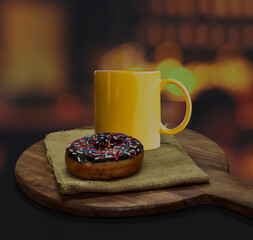 Donut with yellow coffee cup on dark background