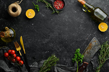 Black stone kitchen background. Kitchen board, vegetables and spices on a black background. Top view.