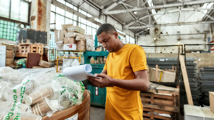 Young african american worker checking data about rubbish
