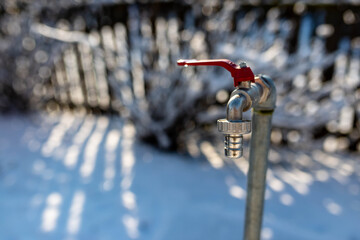 Closed garden water tap close up shot at wintertime , beautiful winter light, space for text.