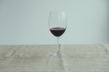 A glass of red wine on a white background on a beige fabric