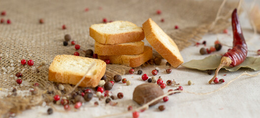 Cereal crisps with cereals close-up on a rough linen background with spices, pepper and chili