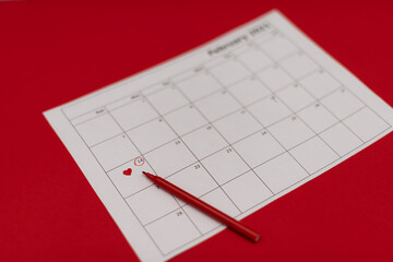 February 14 is marked in red on the calendar there is a red felt tip pen on the calendar