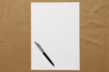 Template of white paper with pen lies on light brown cloth background. Concept of business plan and strategy. Stock photo with empty space for text and design.