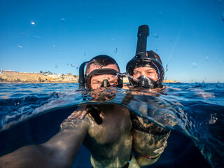 Happy couple snorkeling in Red sea and taking selfie