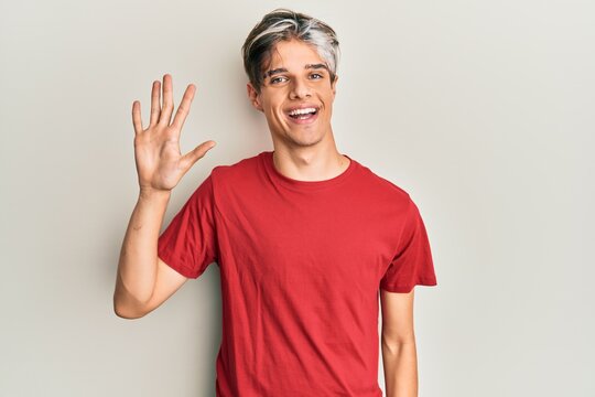 Young hispanic man wearing casual clothes showing and pointing up with fingers number five while smiling confident and happy.