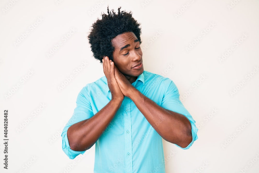 Poster handsome african american man with afro hair wearing casual clothes sleeping tired dreaming and posi