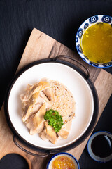 Fototapeta na wymiar Asian Food concept Hainanese Chicken Rice with sour and sweet soy sauce on wooden board with slate stone background