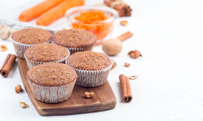 Homemade carrot cake muffins with walnuts on wooden plate, horizontal, copy space