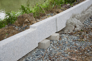 laying a road curb near a reservoir preparation before laying asphalt. selective focus