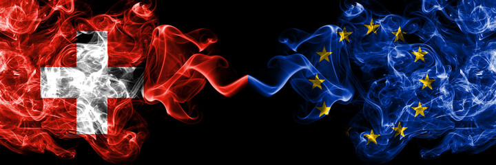 Switzerland, Swiss vs Europe, European, European Union smoky mystic flags placed side by side. Thick colored silky abstract smoke flags.
