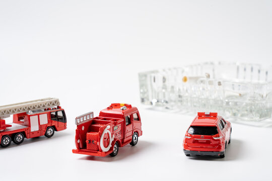 A miniature fire engine is extinguishing the ashtray..Image of fire prevention.