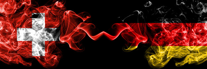 Switzerland, Swiss vs Germany, German, Deutschland smoky mystic flags placed side by side. Thick colored silky abstract smoke flags.