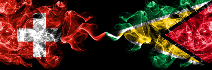 Switzerland, Swiss vs Guyana smoky mystic flags placed side by side. Thick colored silky abstract smoke flags.