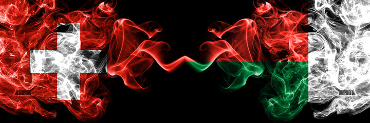 Switzerland, Swiss vs Madagascar smoky mystic flags placed side by side. Thick colored silky abstract smoke flags.