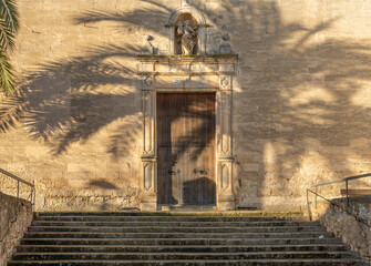 Main facade of the Christian church of Vilafranca de Bonany with the projection of a palm tree