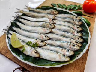 Closeup view of Fresh Indian oil Sardine decorated with herbs and vegetables,Selective focus.White Background.