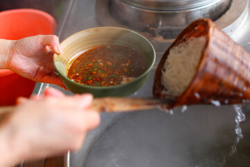 A Person frying noodles in a wok