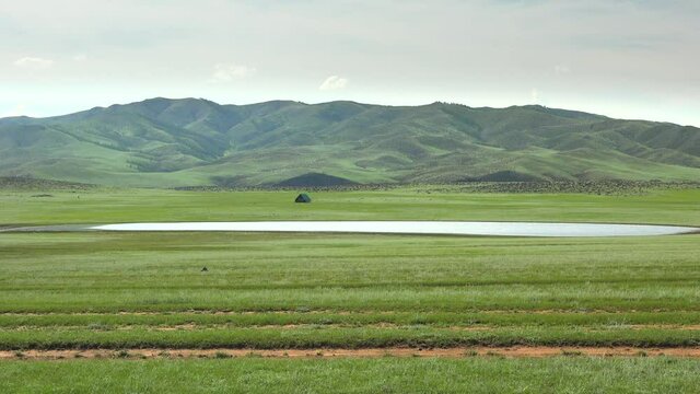 A lonely house by the lake in the treeless meadow.Colorful roofed chalet in Mongolia.Landscape roof mere lough wetland pond water lakeside lakeshore waterside littoral Mongolian Central Asia