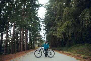 Cyclist girl with mountain bike in forest