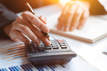 Closeup of female who are using their fingers to press the calculator for calculating bills in the office.finance report. Business office concept. - obrazy, fototapety, plakaty